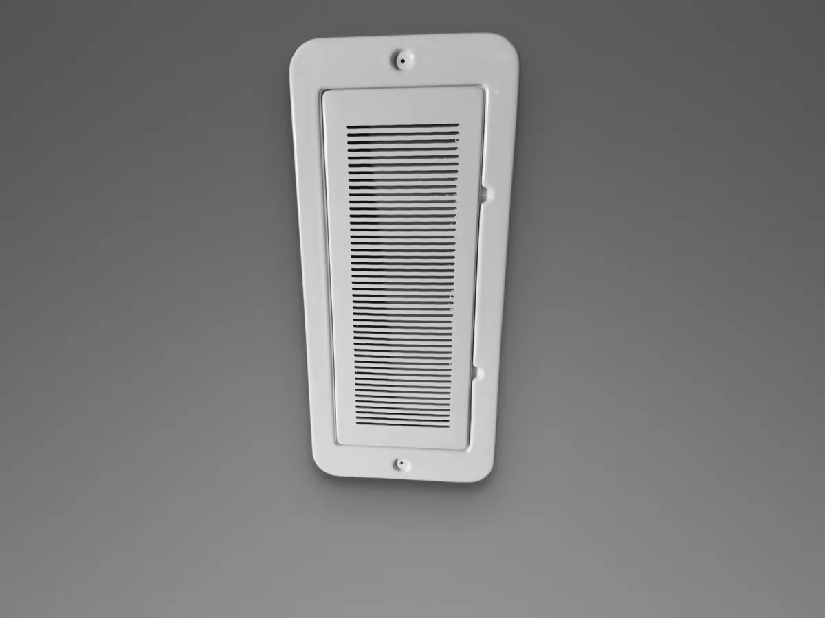 Painel de shaft com veneziana, variante que mantém ventilação no vão, sobre fundo cinza