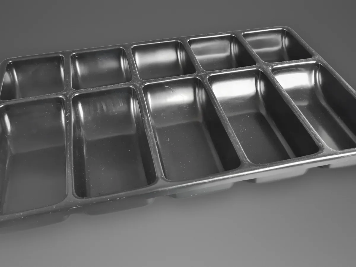 Bandeja cinza termoformada com dez cavidades retangulares fundas, em duas fileiras de cinco
