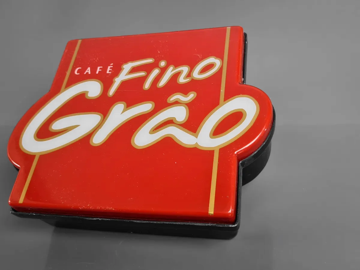 Frente de luminoso do Café Fino Grão, recortada no contorno da marca, em vermelho com letras em relevo